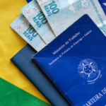 Carteira de Trabalho, notas de 100 reais e bandeira do Brasil