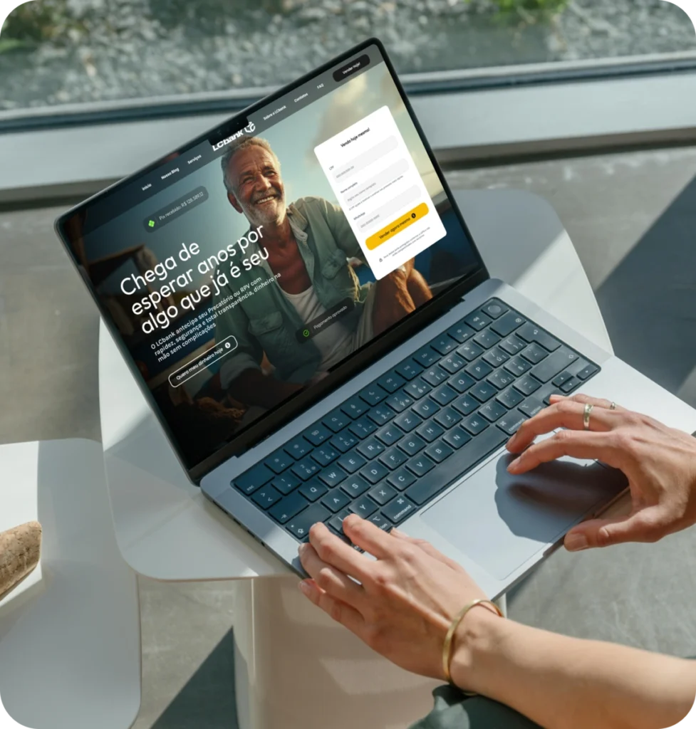 Laptop aberto mostrando o site LCbank com login e frase "Chega de esperar anos por algo que já é seu