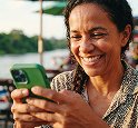 Homem sorrindo olhando o celular